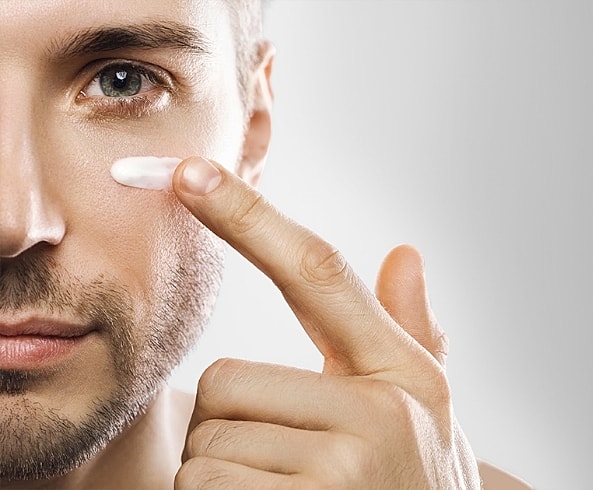 Man applying skincare product to his face.