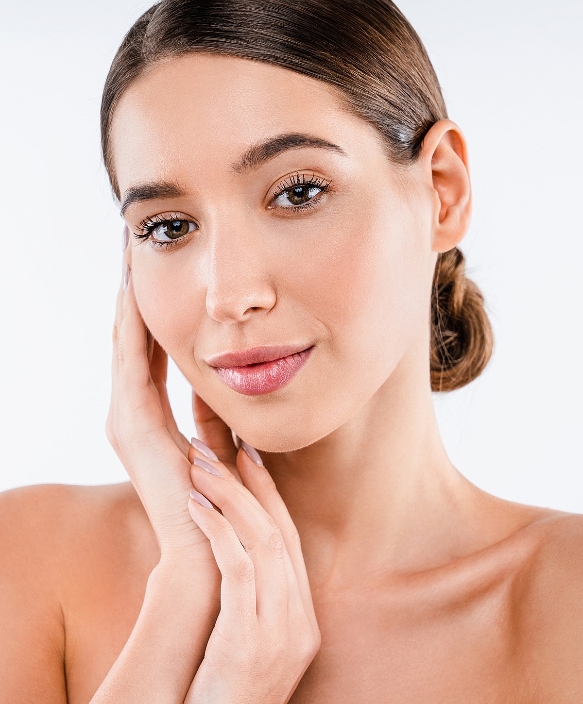 Woman with gray hair gently touching her face.
