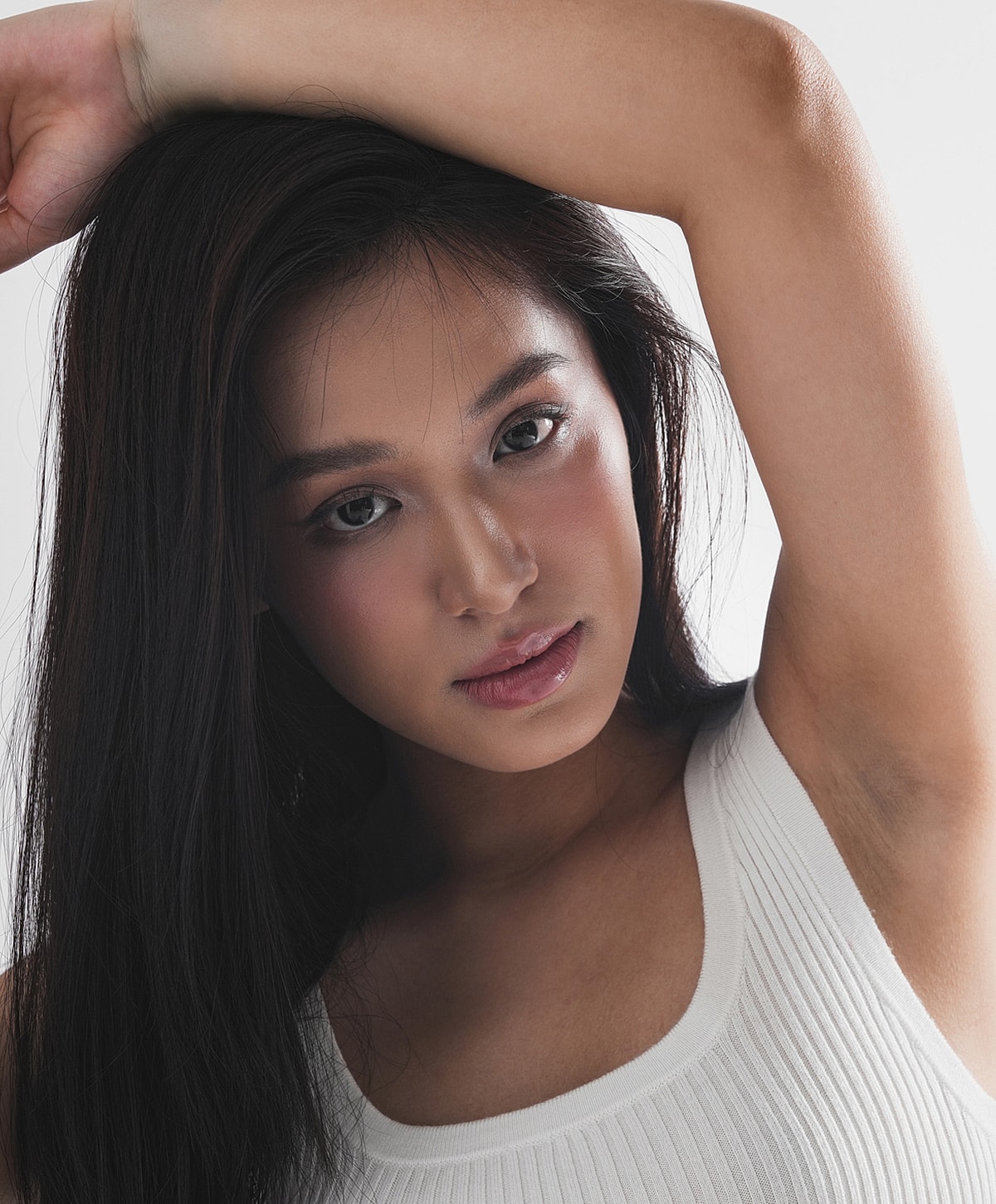 Model posing with long hair and tank top.