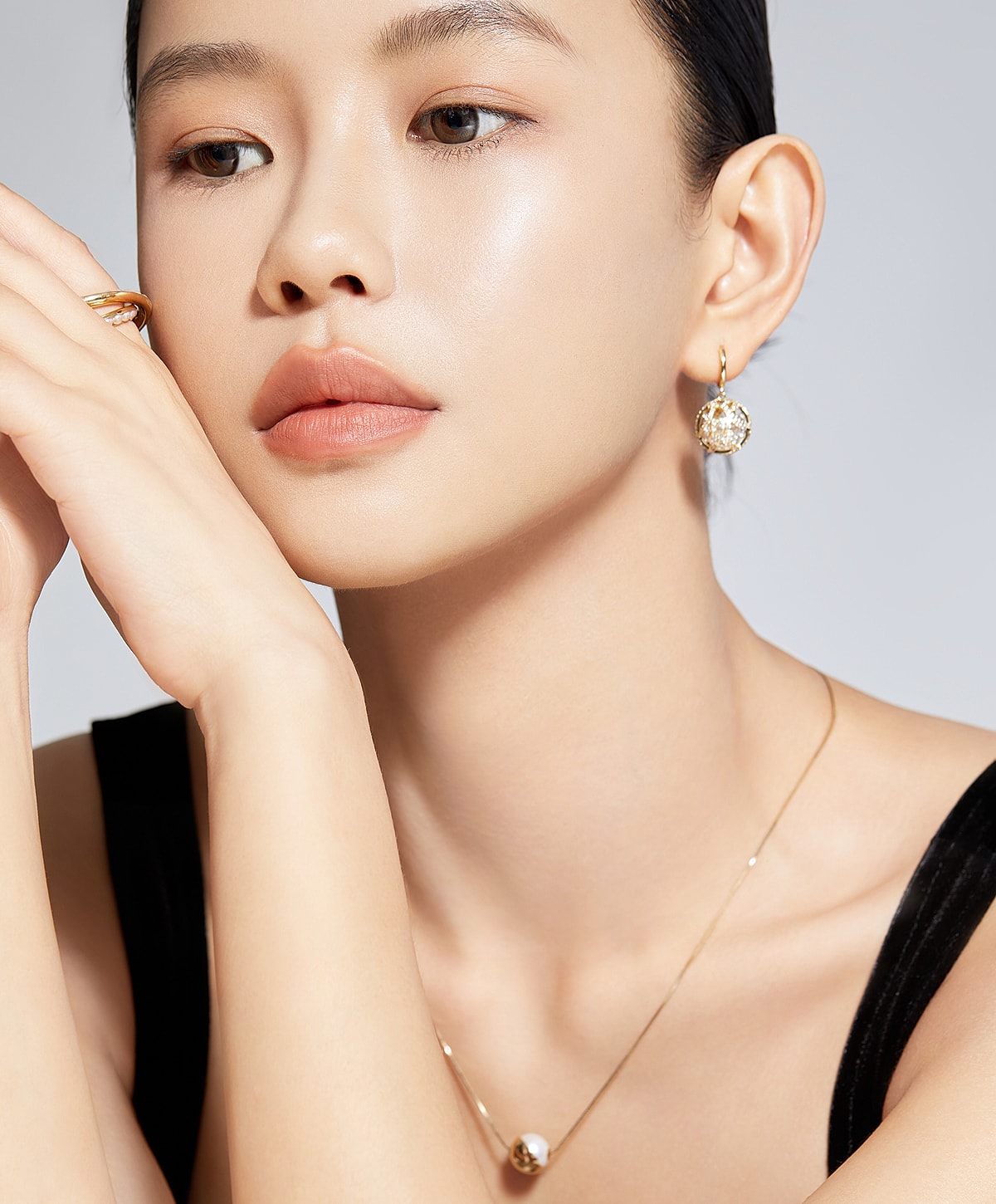 Model showcasing elegant jewelry and natural beauty.
