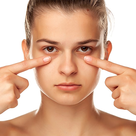 Young woman demonstrating a skincare technique.