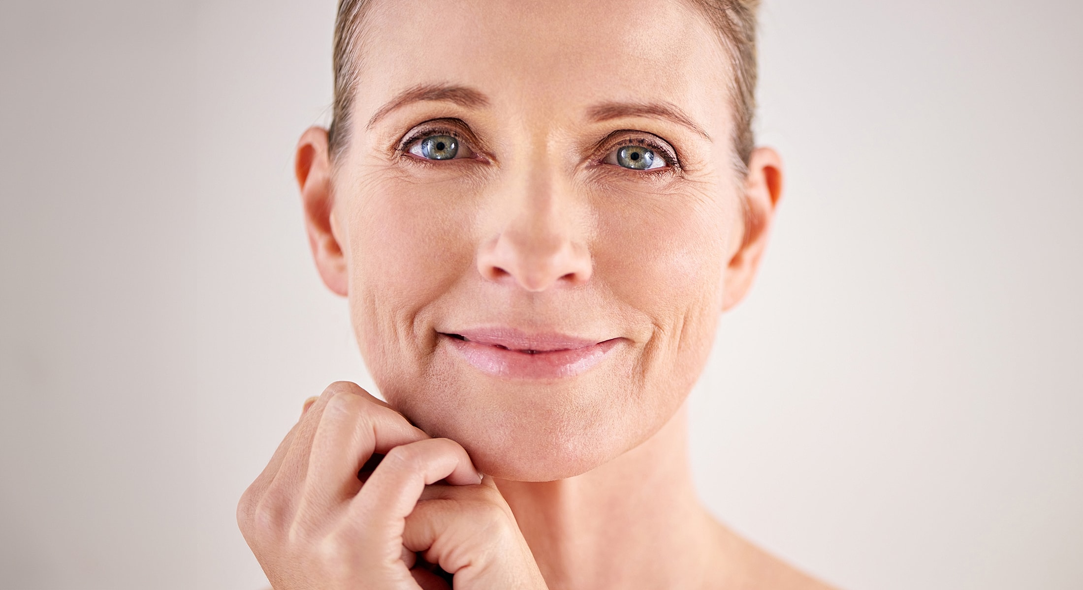 Smiling woman touching her chin thoughtfully.