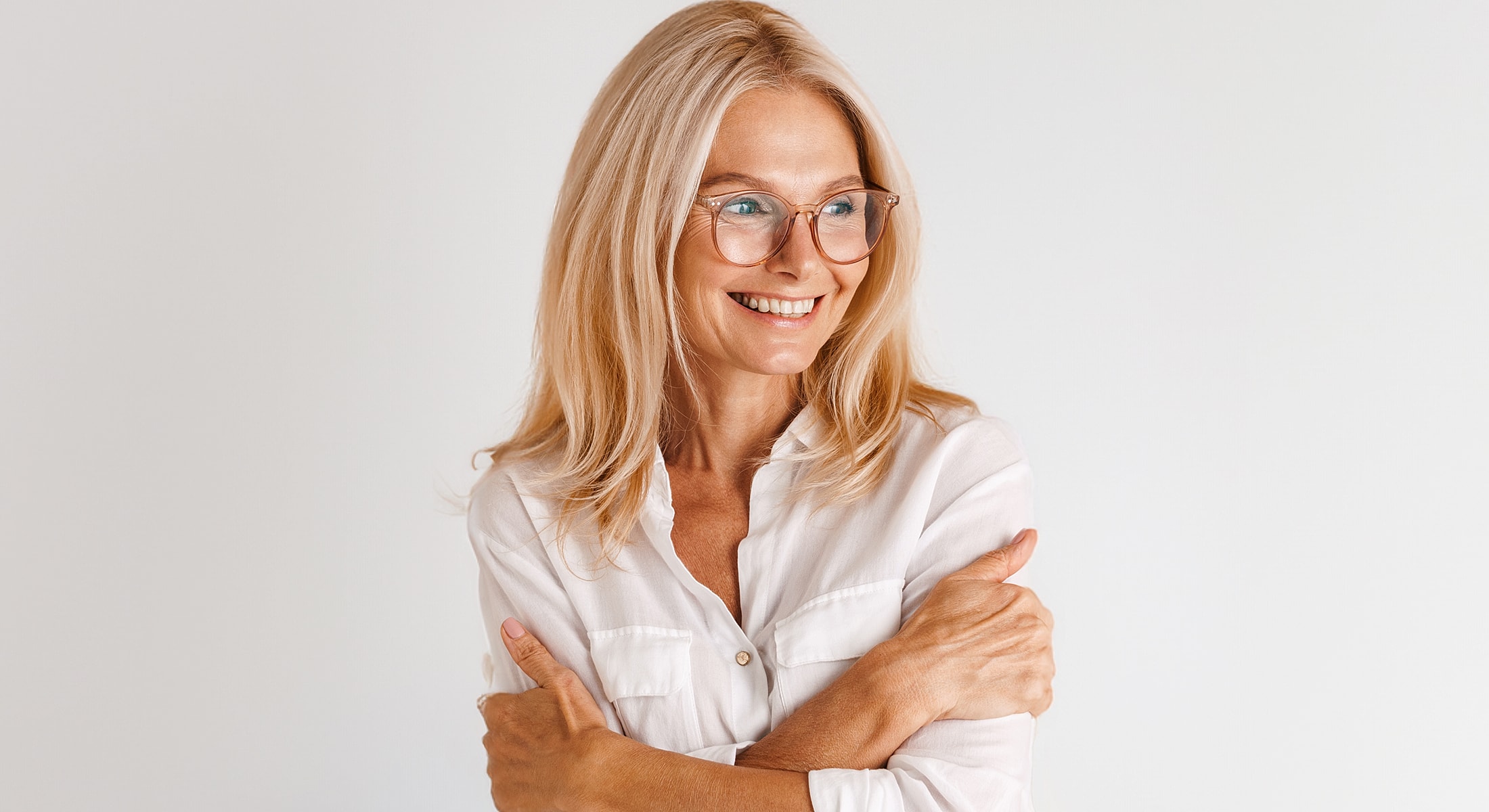 Smiling woman with glasses and long blonde hair.