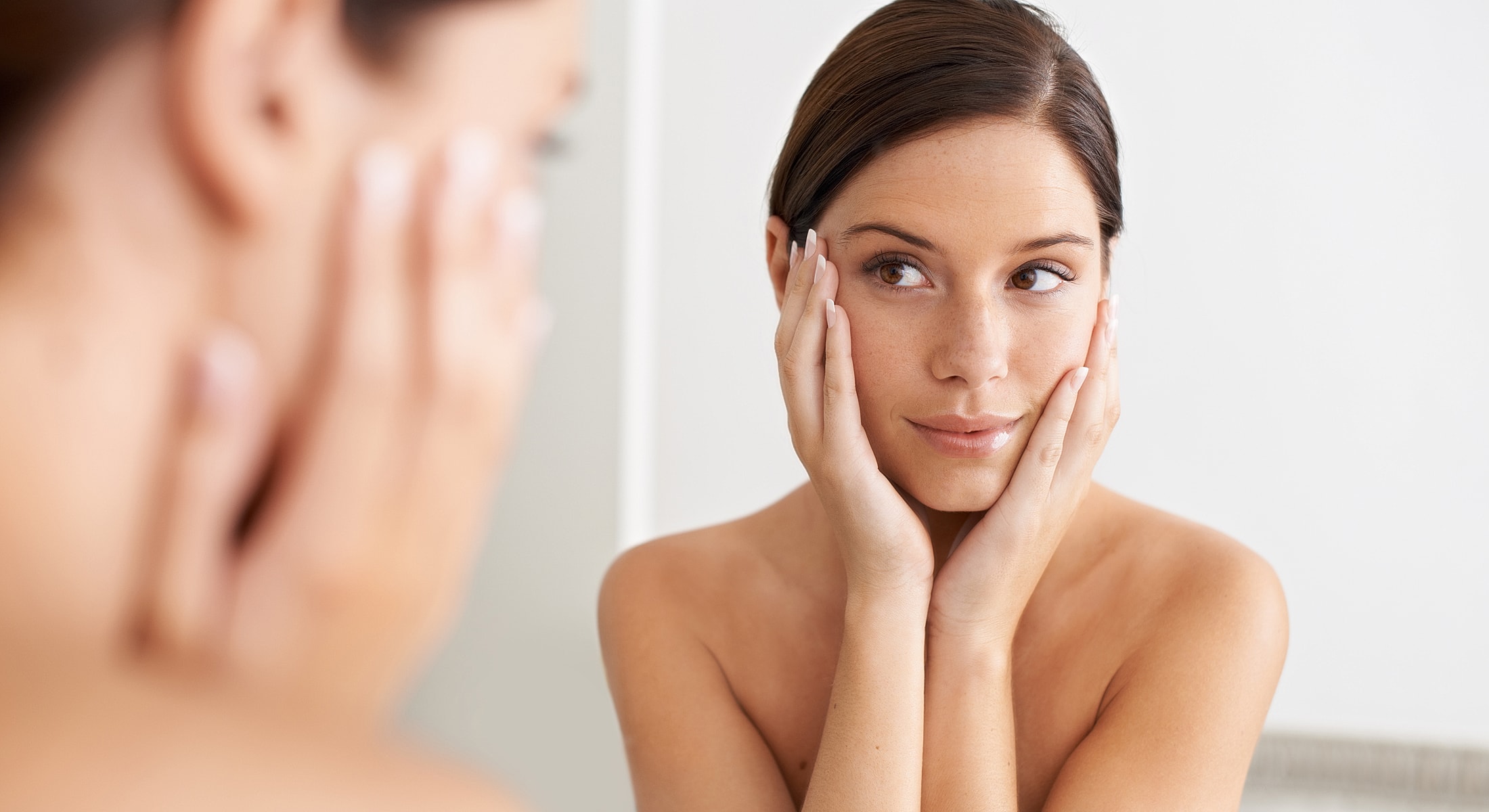 Woman admiring reflection in a mirror.